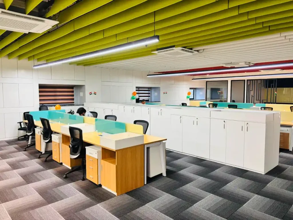 Modern commercial office corridor with carpet flooring, glass cabins and linear ceiling design completed in Gurgaon.